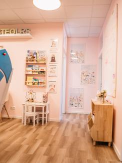 Heller Raum mit Kindermöbeln, Büchern und Wandbildern in freundlicher Farbgestaltung