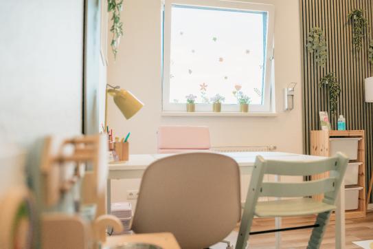 Innenraum mit kindgerechter Einrichtung, Fensterdeko und organisiertem Schreibtisch