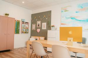 Innenraum mit Tisch, Stühlen, Kinderecke, farbigen Möbeln und kreativer Wandgestaltung